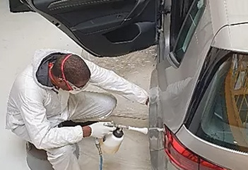 Un Mécanicien Automobile Utilise Un Spray Pour Nettoyer Les